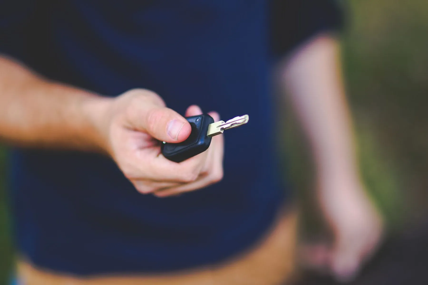 A car key held out in an open hand